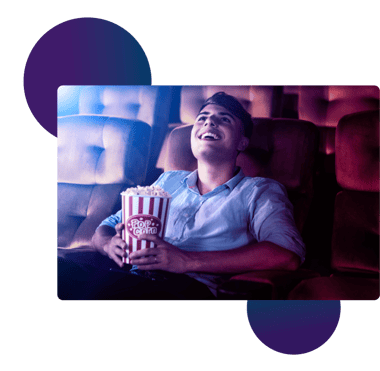 Junger Mann mit Popcorn in einem Kinosaal
